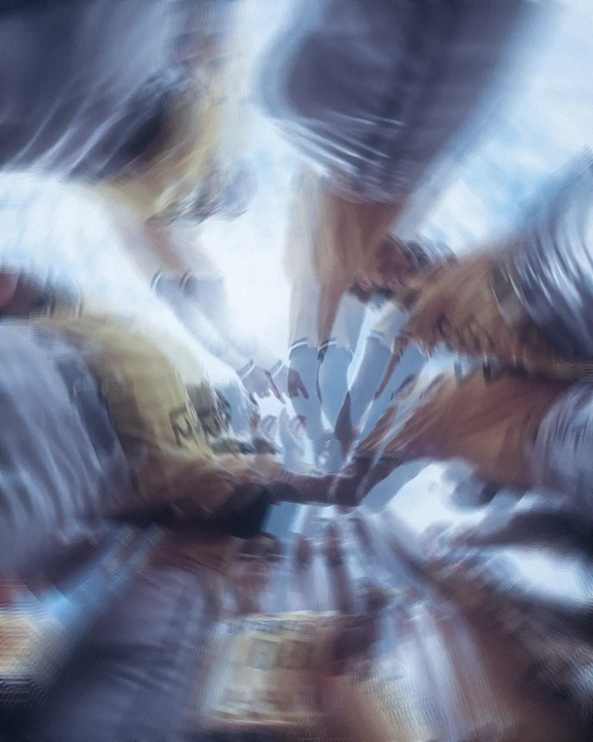 Athletes bringing their hands together in a team huddle